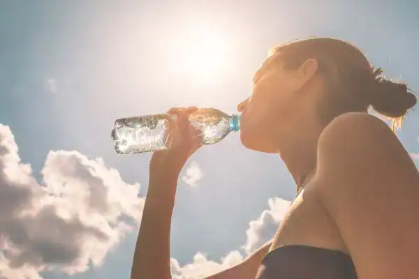 Hydration: The Secret Ingredient for a Toned Stomach and Enhanced Fitness 3 Image of woman drinking water to hydrate Reigate after run.